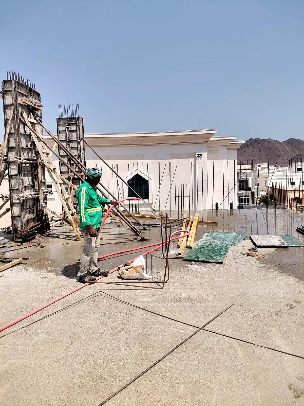 Column formwork with props on an upper slab beside completed villas