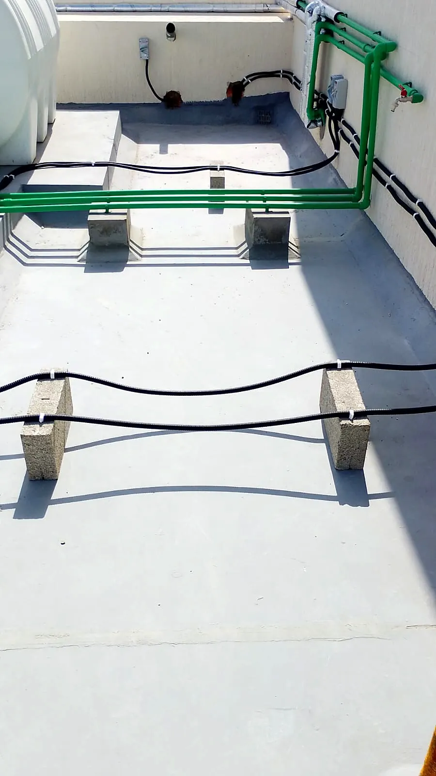 Roof with protective coating, cable routes and service plinths