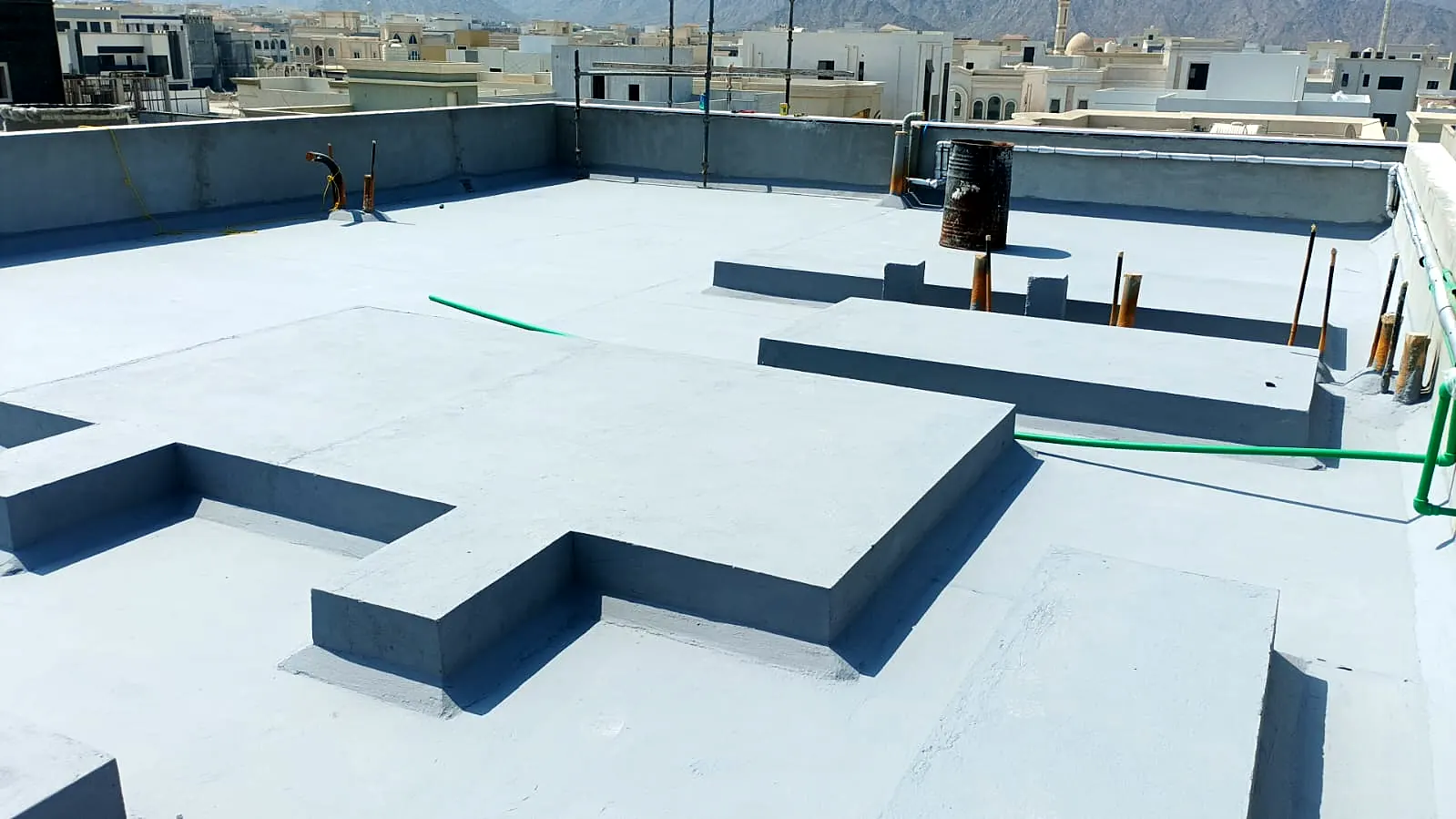 Finished grey roof coating with raised plinths for building services