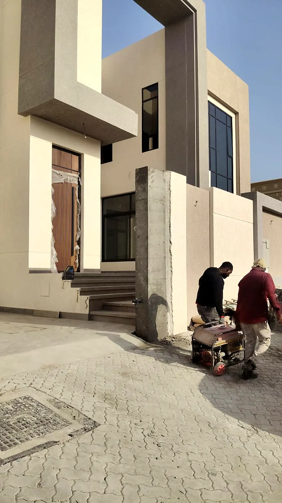 Villa entrance with stone-clad steps and interlocking paving