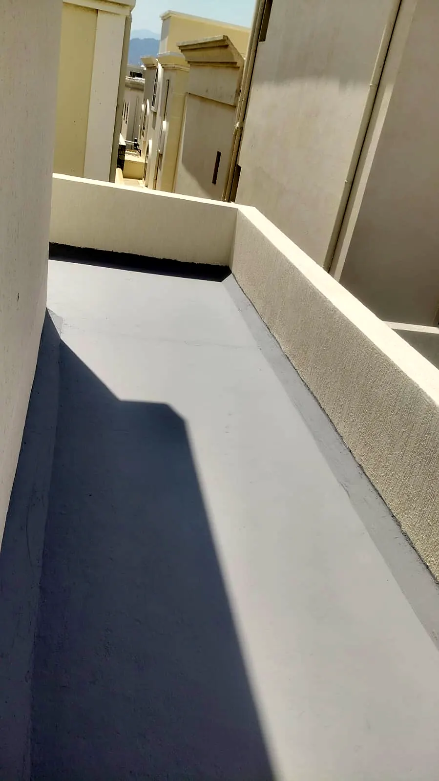 Waterproofed terrace walkway beside a parapet wall